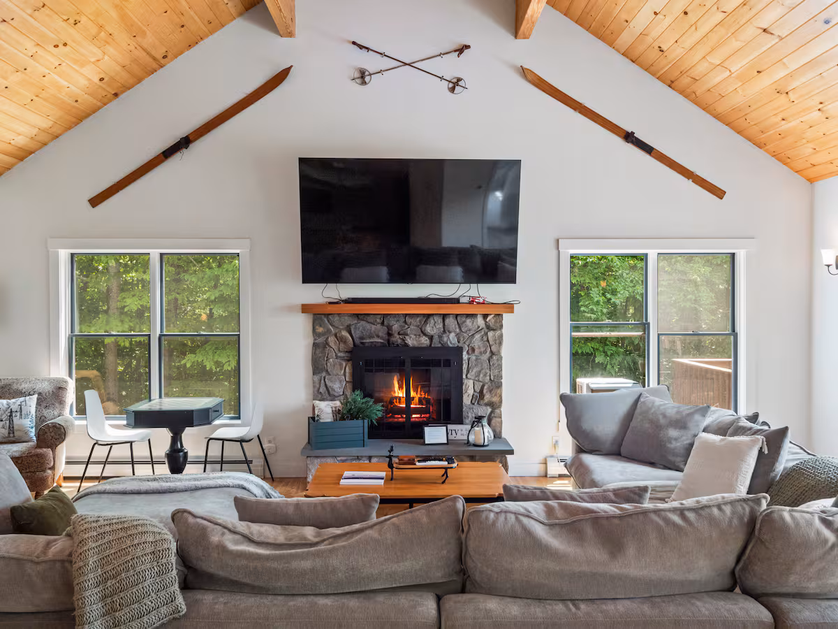 Main living area with large TV over a stone fireplace.